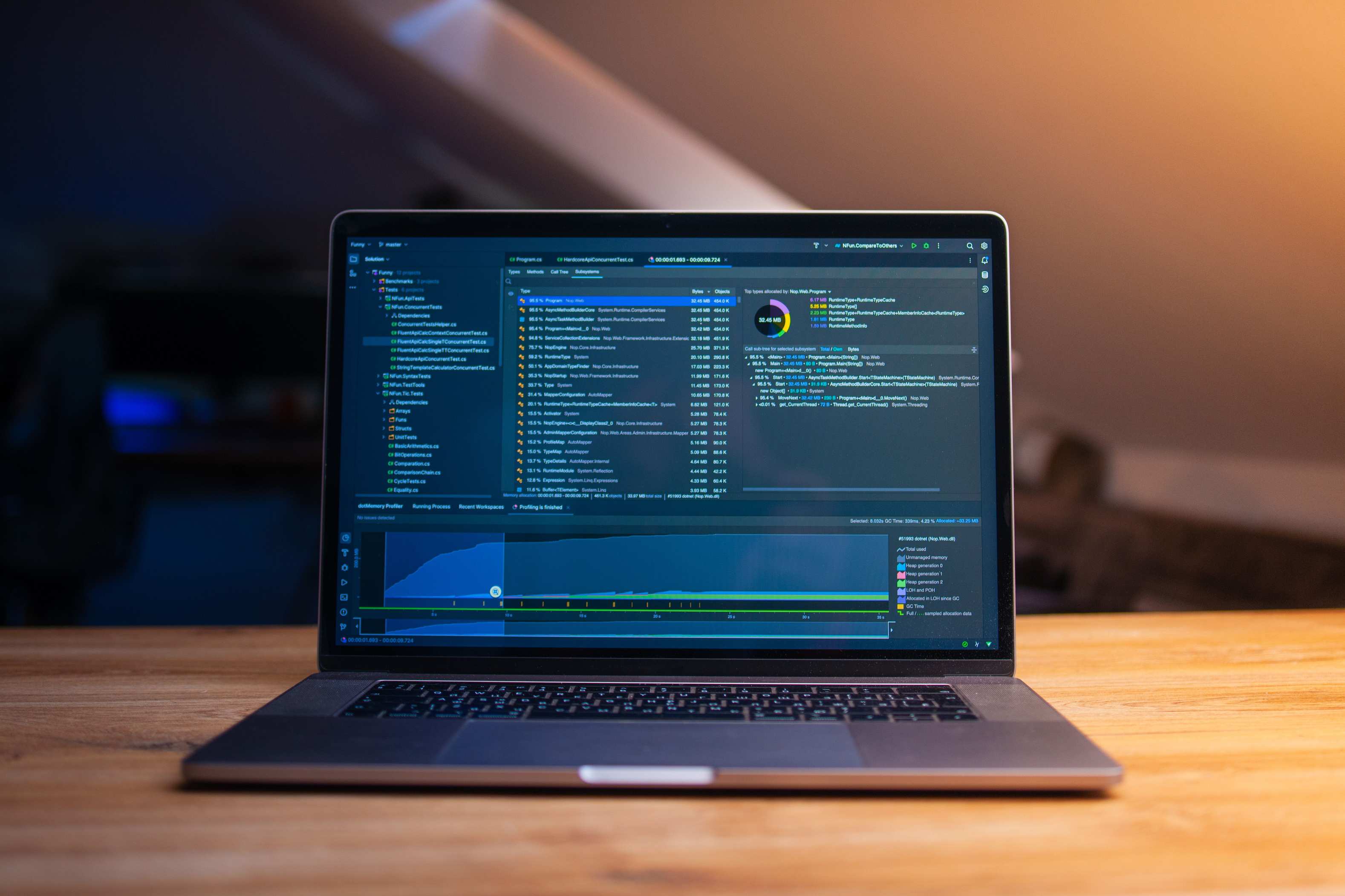 Laptop mit Tabellenkalkulation auf einem Schreibtisch bei abendlicher Beleuchtung, wooden desk